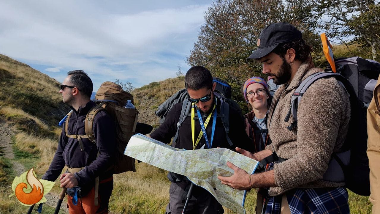 Gruppo di partecipanti al corso di escursionismo mentre leggono una cartina in ambiente