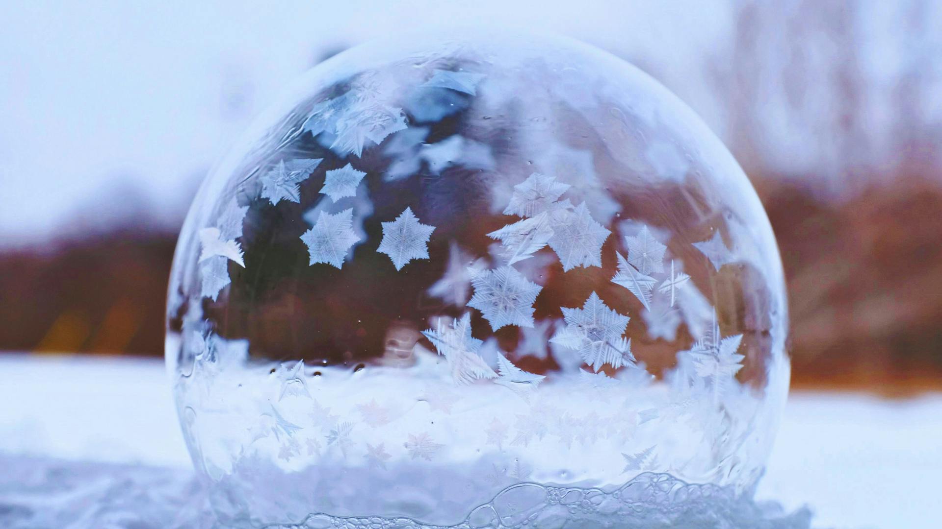 bolla di sapone con cristalli di neve all'interno in ambiente innevato