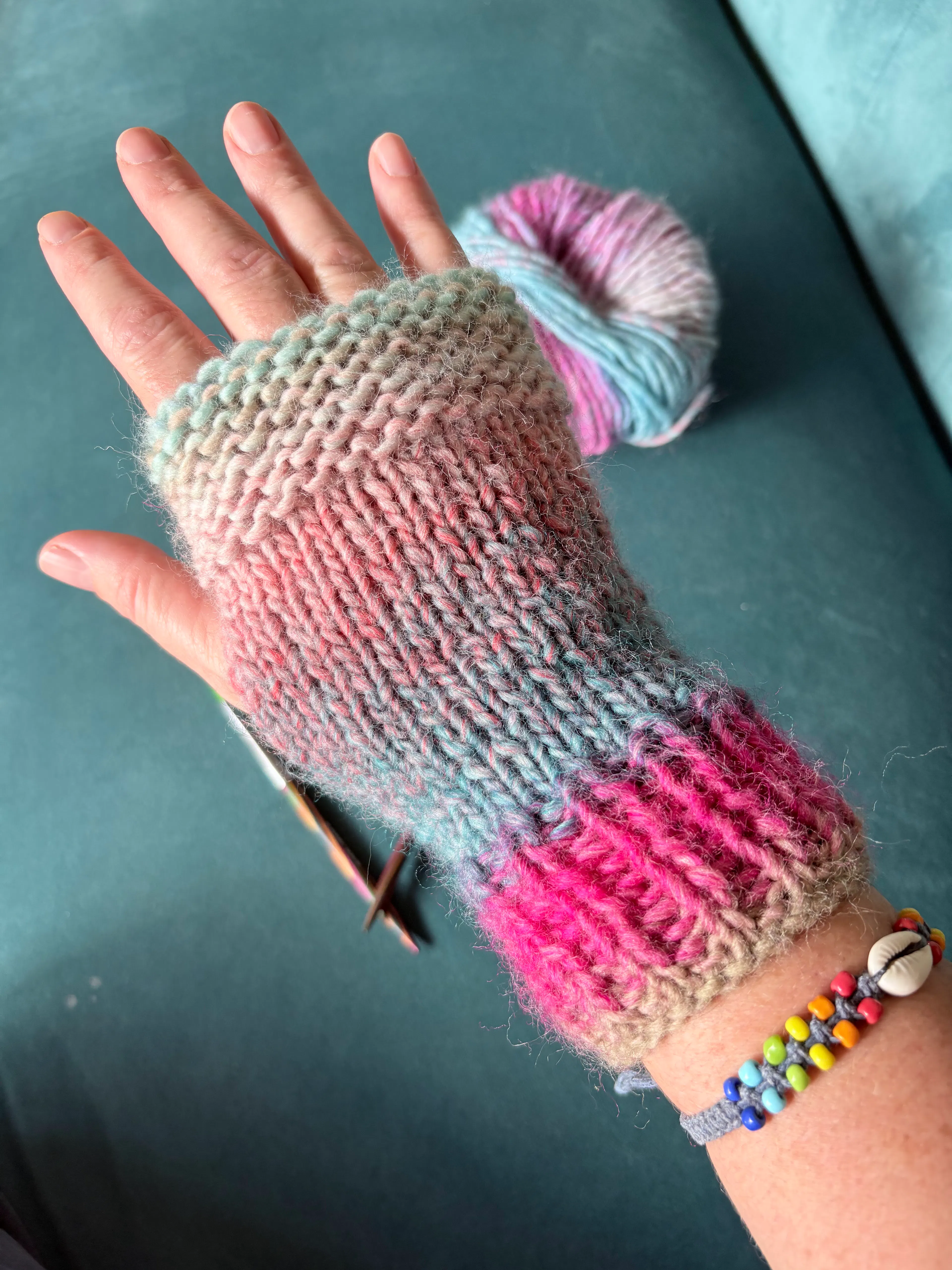 a multicoloured handwarmer on a hand