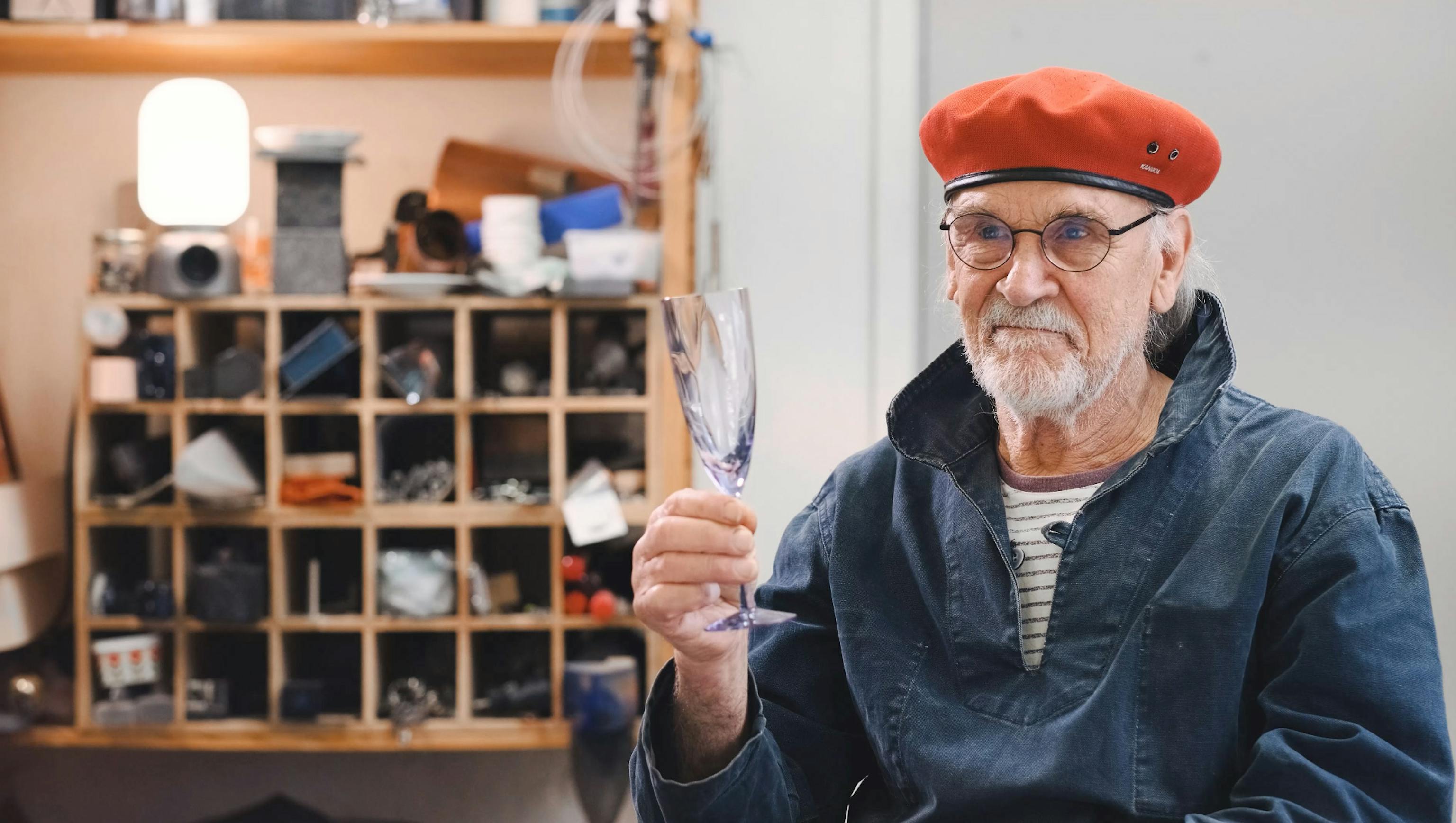Bertil Vallien med höjt glas i hand från Kosta Boda