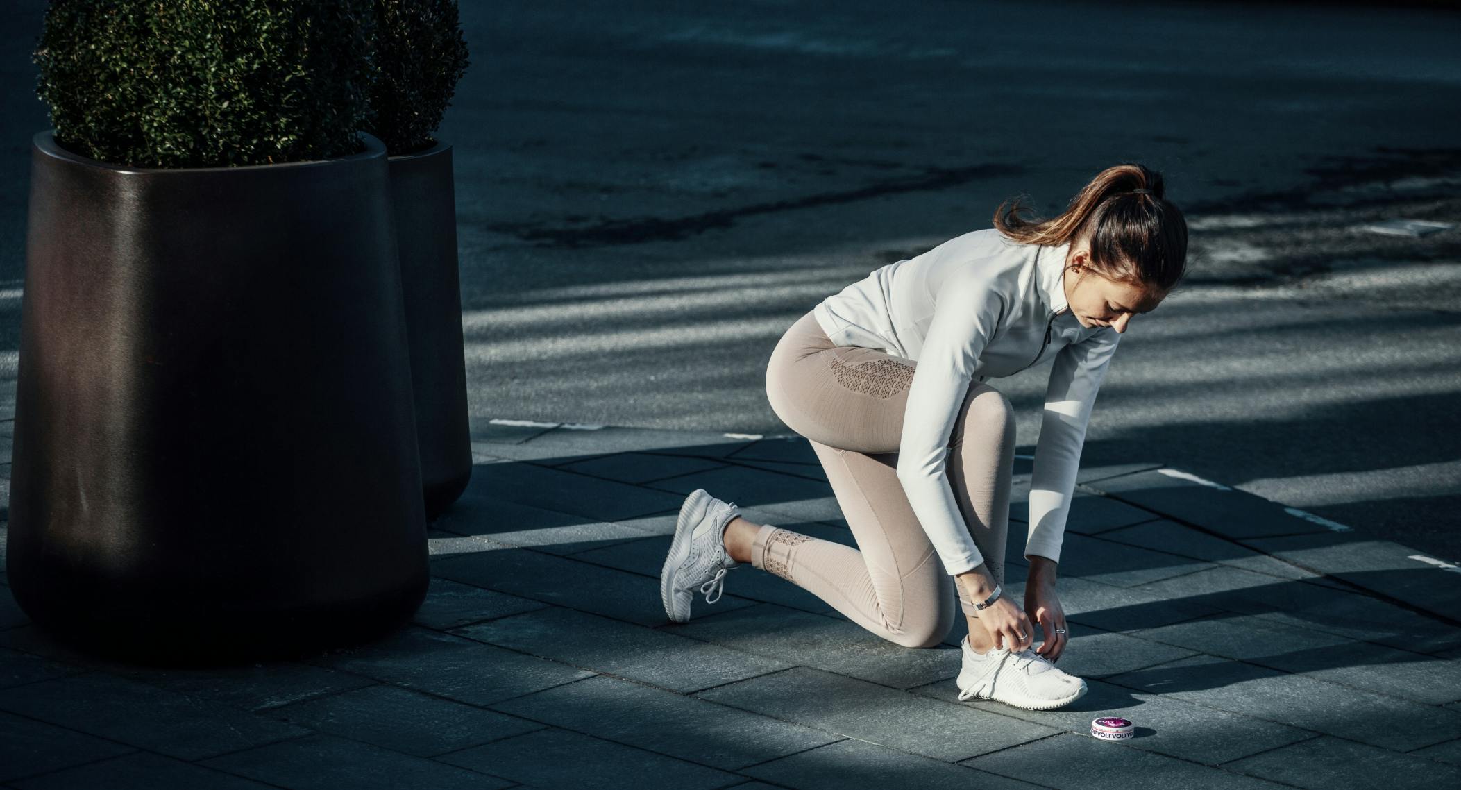 Kvinna knyter skorna med en dosa framför sig - Haypp Group