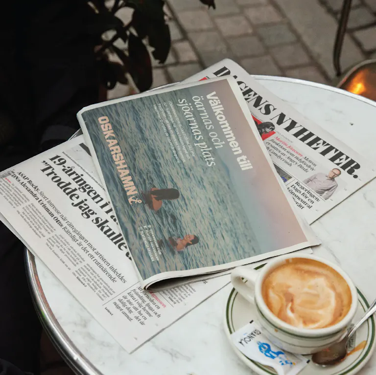 Cafébord med tidning som visar Oskarshamn-annons