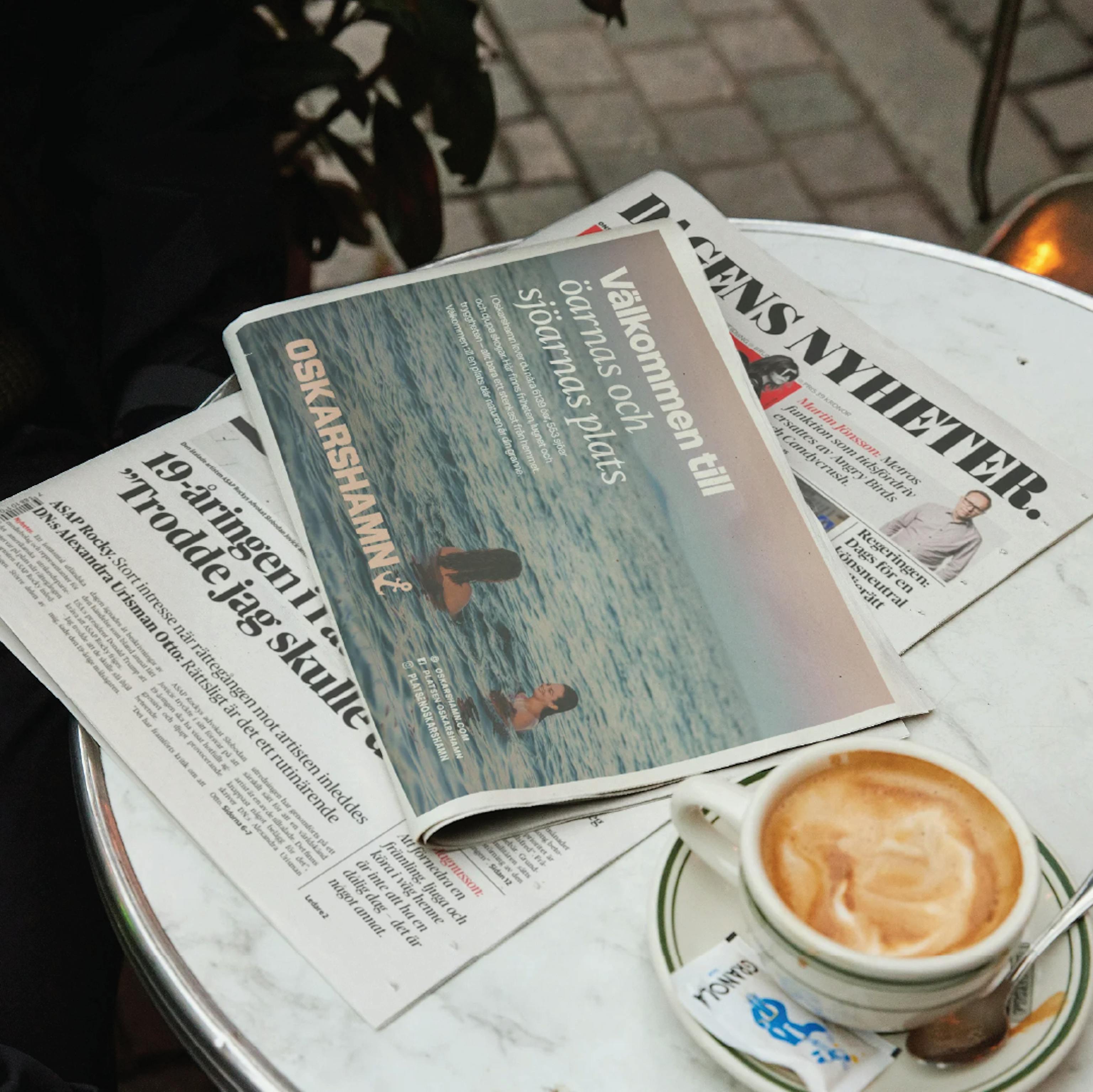 Cafébord med tidning som visar Oskarshamn-annons