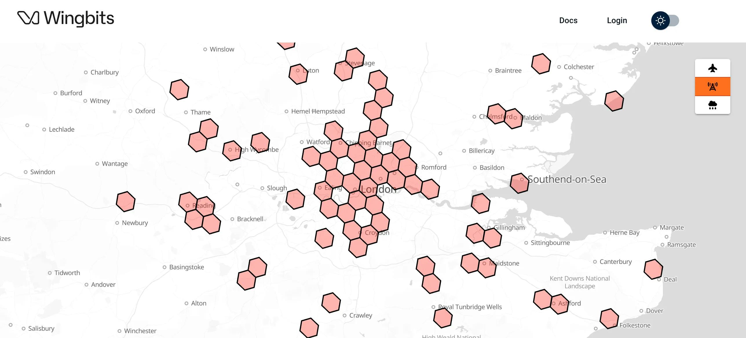 Map view of Wingbits network coverage around London showing pink hexagonal coverage areas concentrated around London with scattered coverage extending to surrounding areas like Oxford, Winchester, and Canterbury. Map includes city names and a legend showing toggle options for planes, antennas, and weather layers.