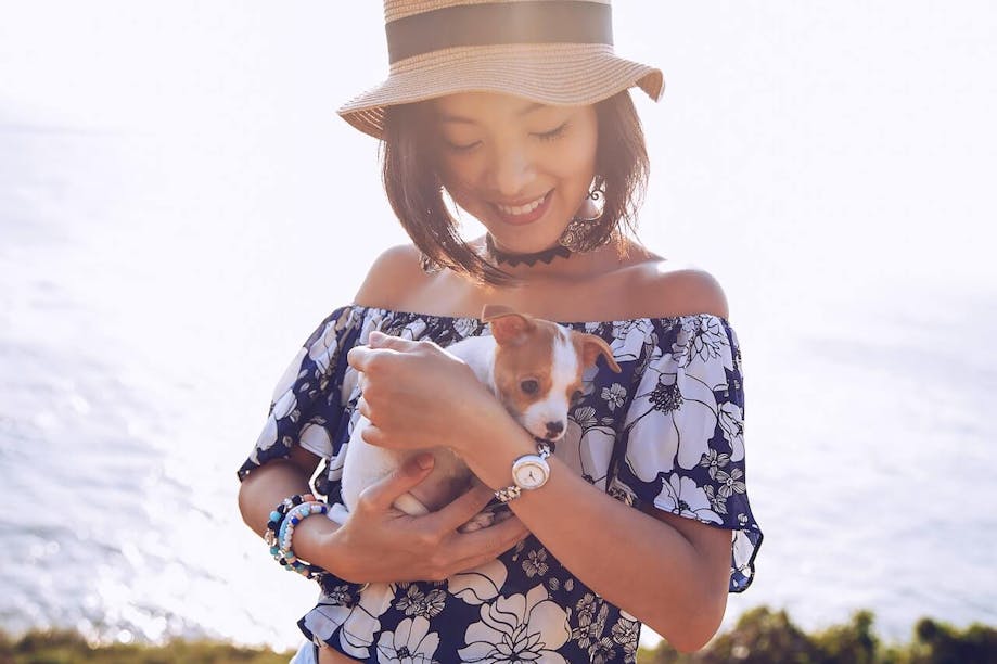 Woman holding puppy and smiling