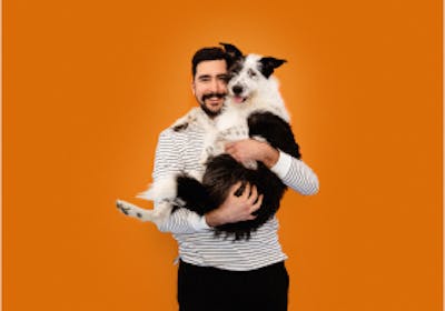 A man holding a big scruffy dog in his arms