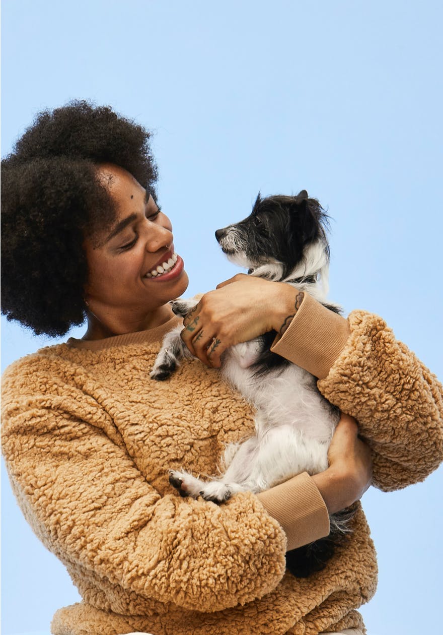 A woman holding a puppy while smiling