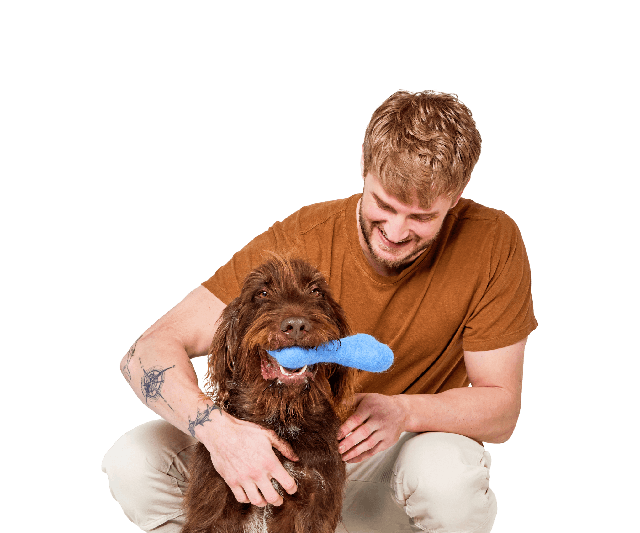 Young man holding his brown mixed terrier breed dog holding a dog toy