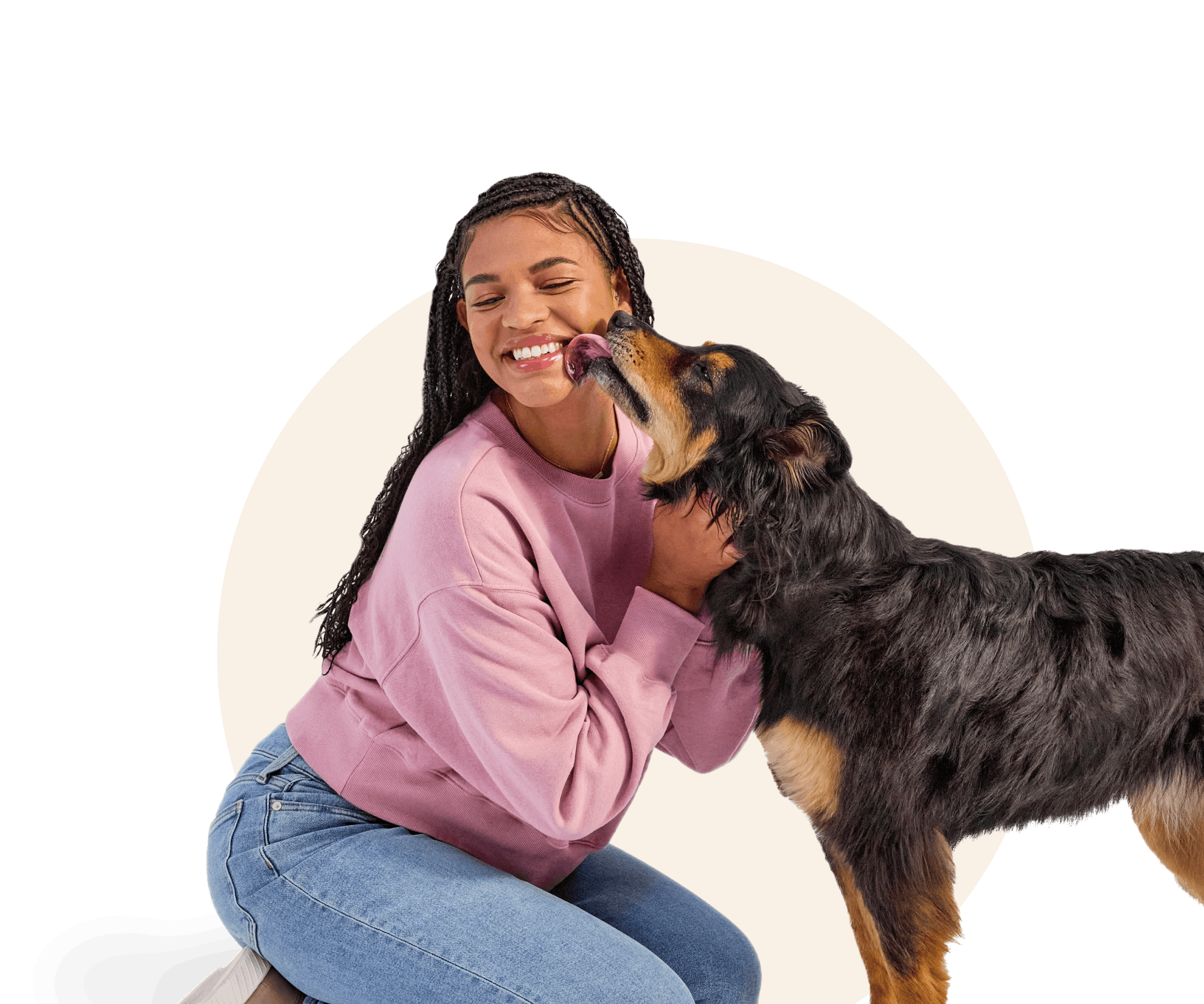 Young woman smiling and getting licked by her cute black and brown mixed breed furry dog