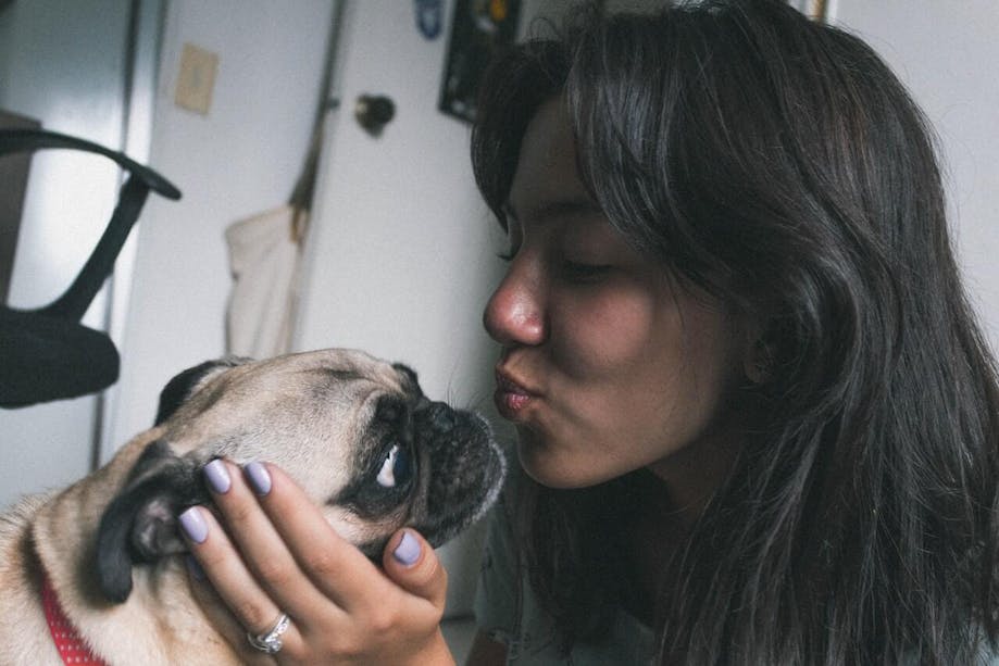 Woman making kissing face at dog