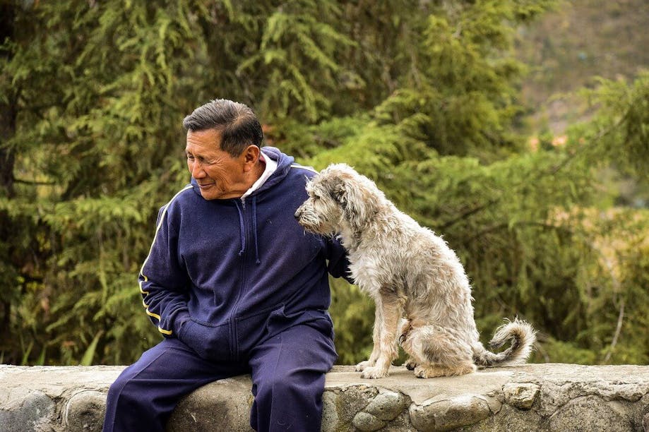 Elderly man sitting next to his dog
