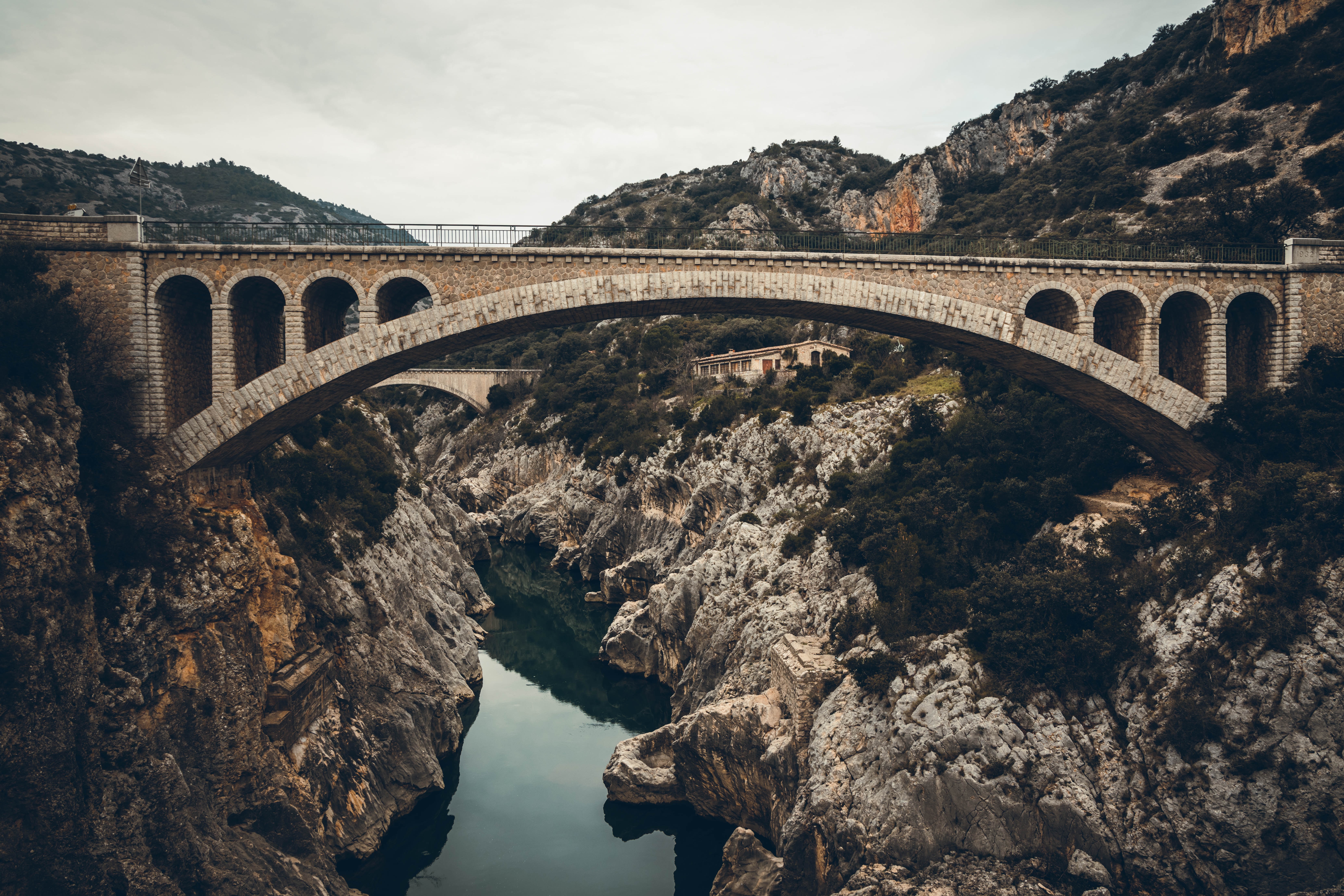 A stone bridge over a deep ravine with a river flowing through it