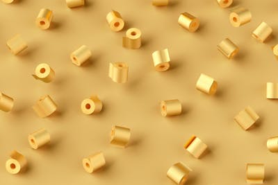 Pattern from flying rolls of golden painted toilet paper on a gold background with soft shadow.