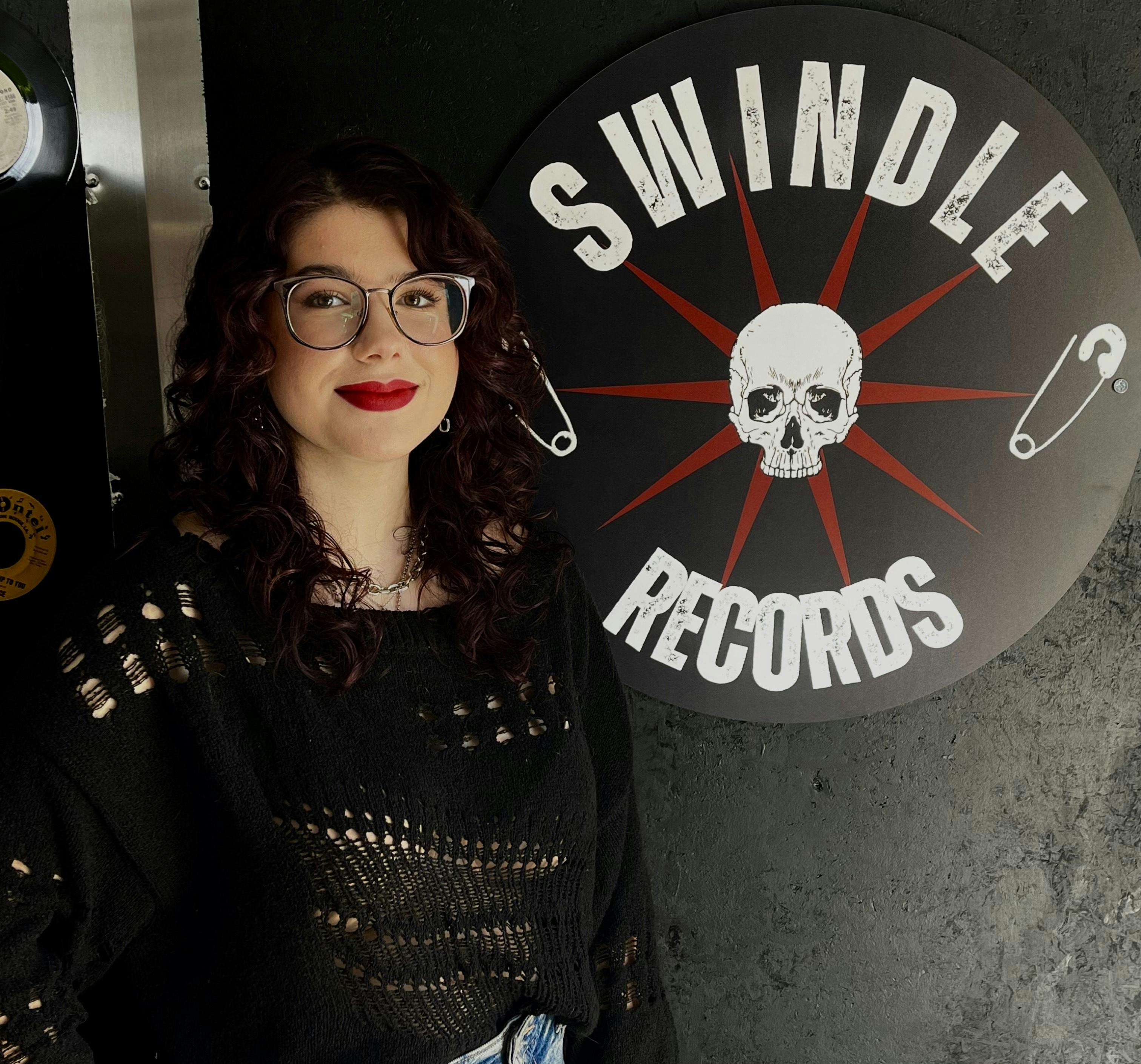 Portrait of Morgan with Swindle Records Logo