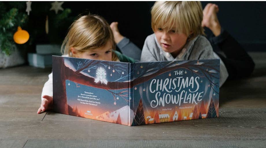 Brother and sister reading The Christmas Snowflake together