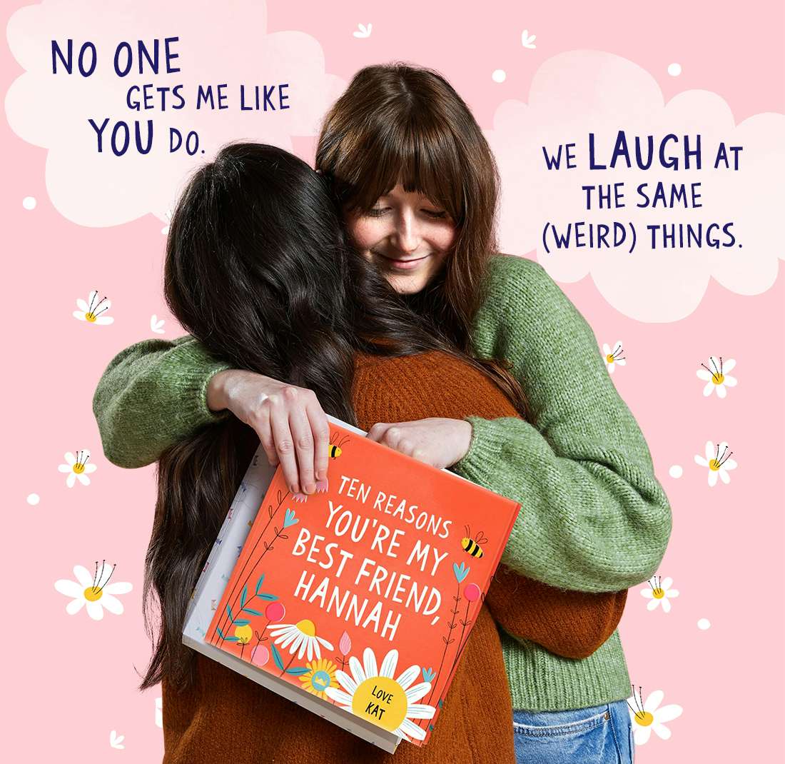 Two friends hugging whilst holding Ten Reasons You're My Best Friend