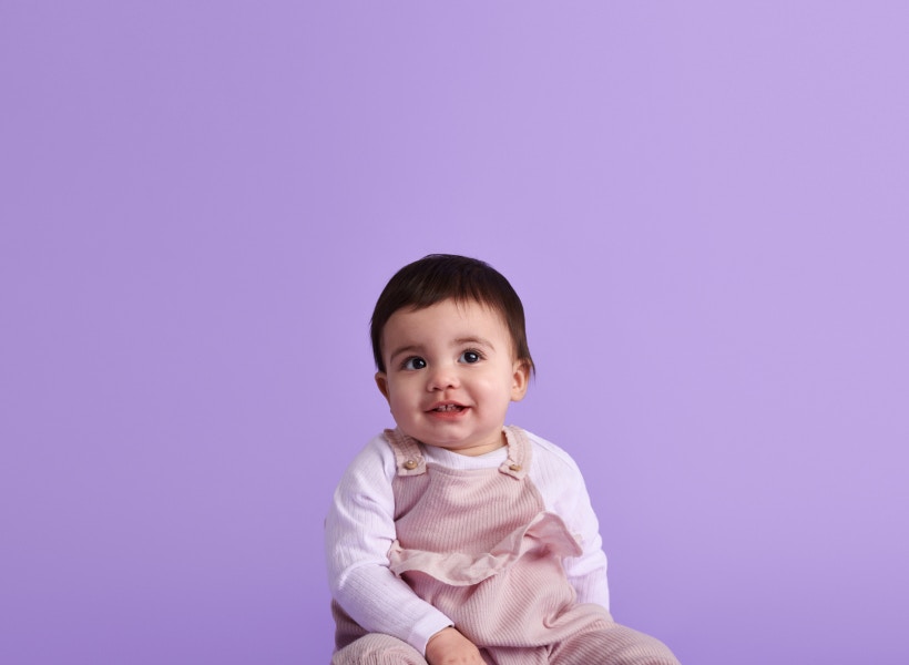 purple background with baby smiling