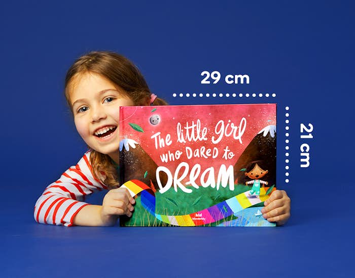 Child holding Dared to Dream book showing dimensions 29cm length by 21 cm height