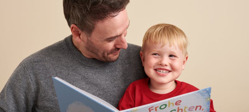 Baby und Papa lesen ein Buch