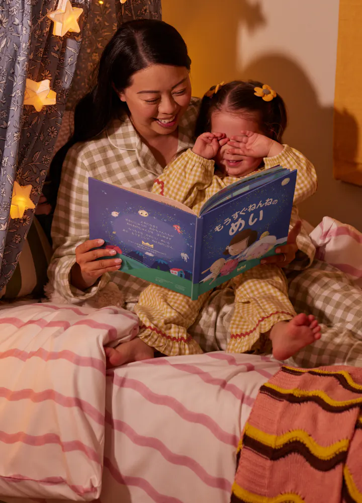 パーソナライズ絵本を読む子供と母親
