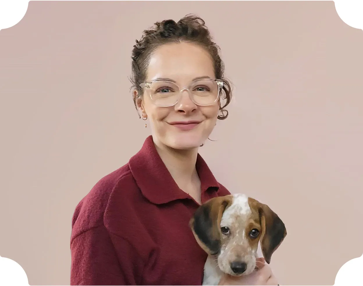 Illustrator Jenny Wren wearing a dark red shirt, holding a puppy