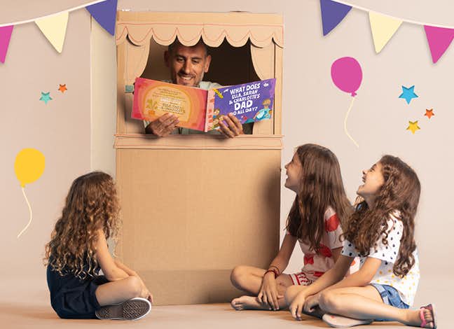man reading to kids in a little puppet show box