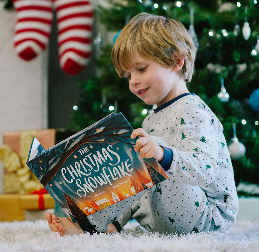 Little boy reading The Christmas Snowflake