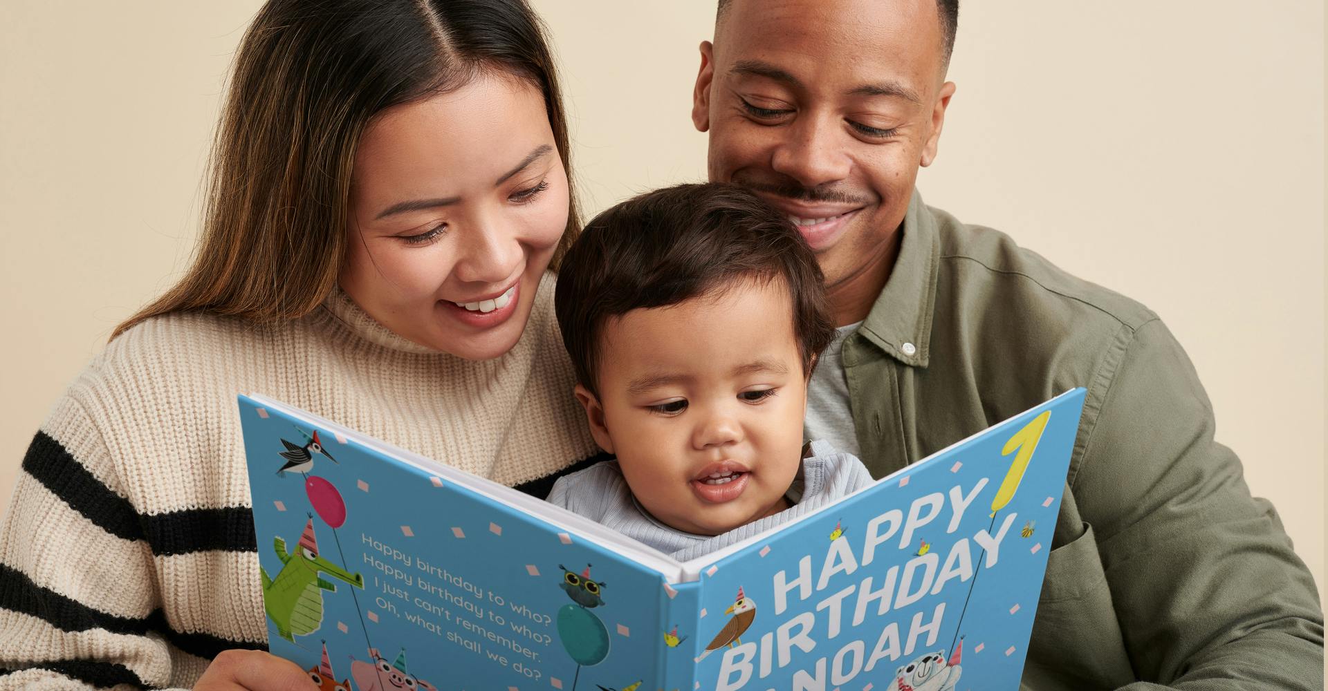 infant and parents reading Happy Birthday to You