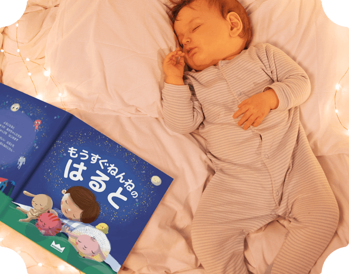 本の隣で眠る赤ちゃん
