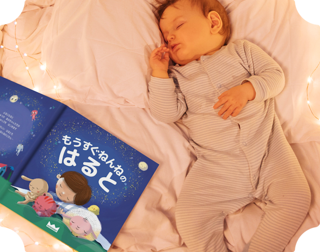本の隣で眠る赤ちゃん