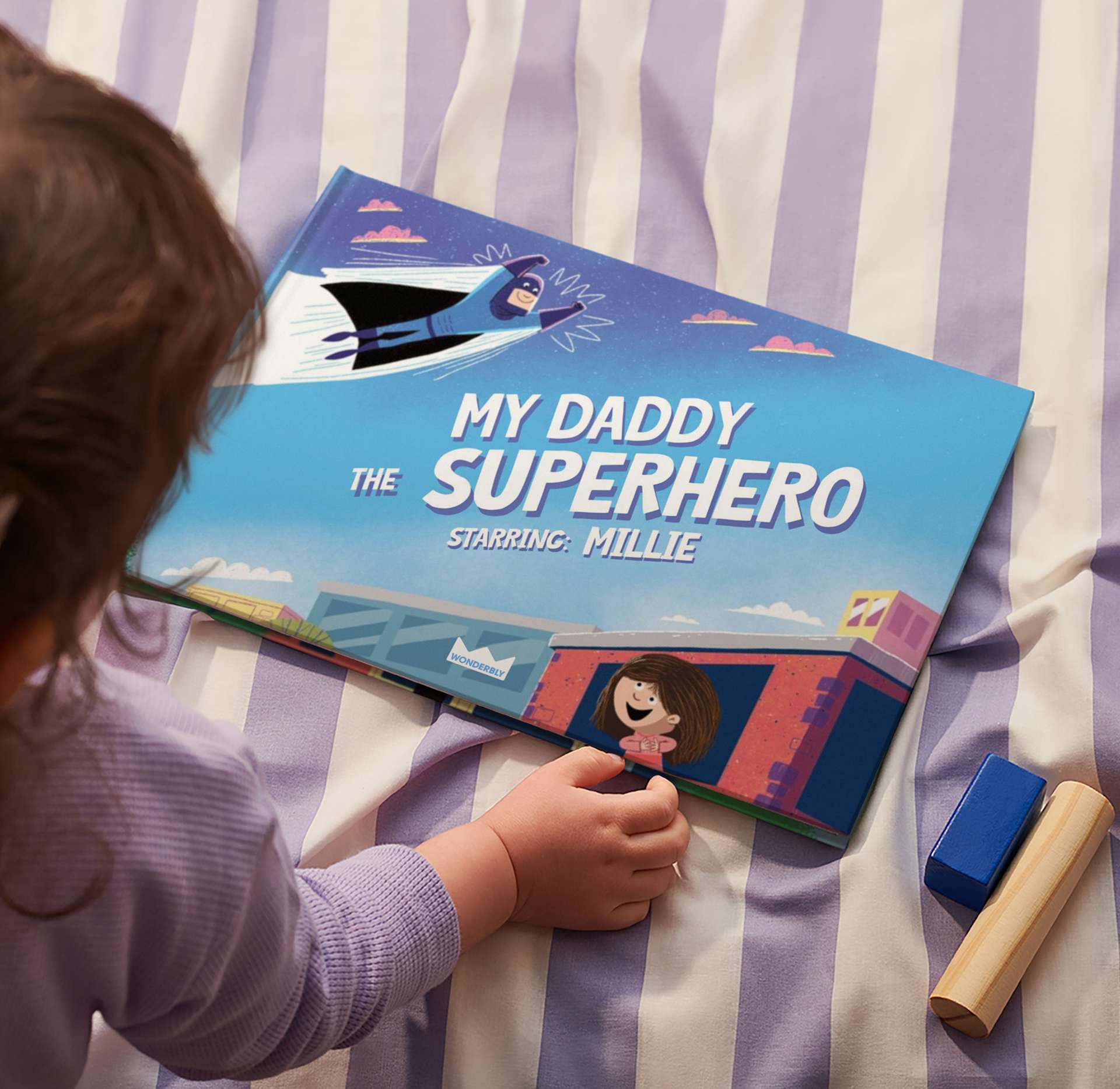 child looking at book on the bed