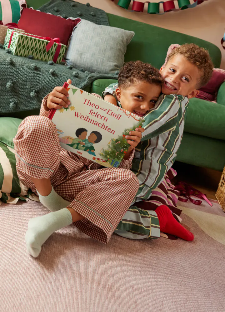 Zwei Kinder beim Lesen des personalisierten Buches - Wir feiern Weihnachten