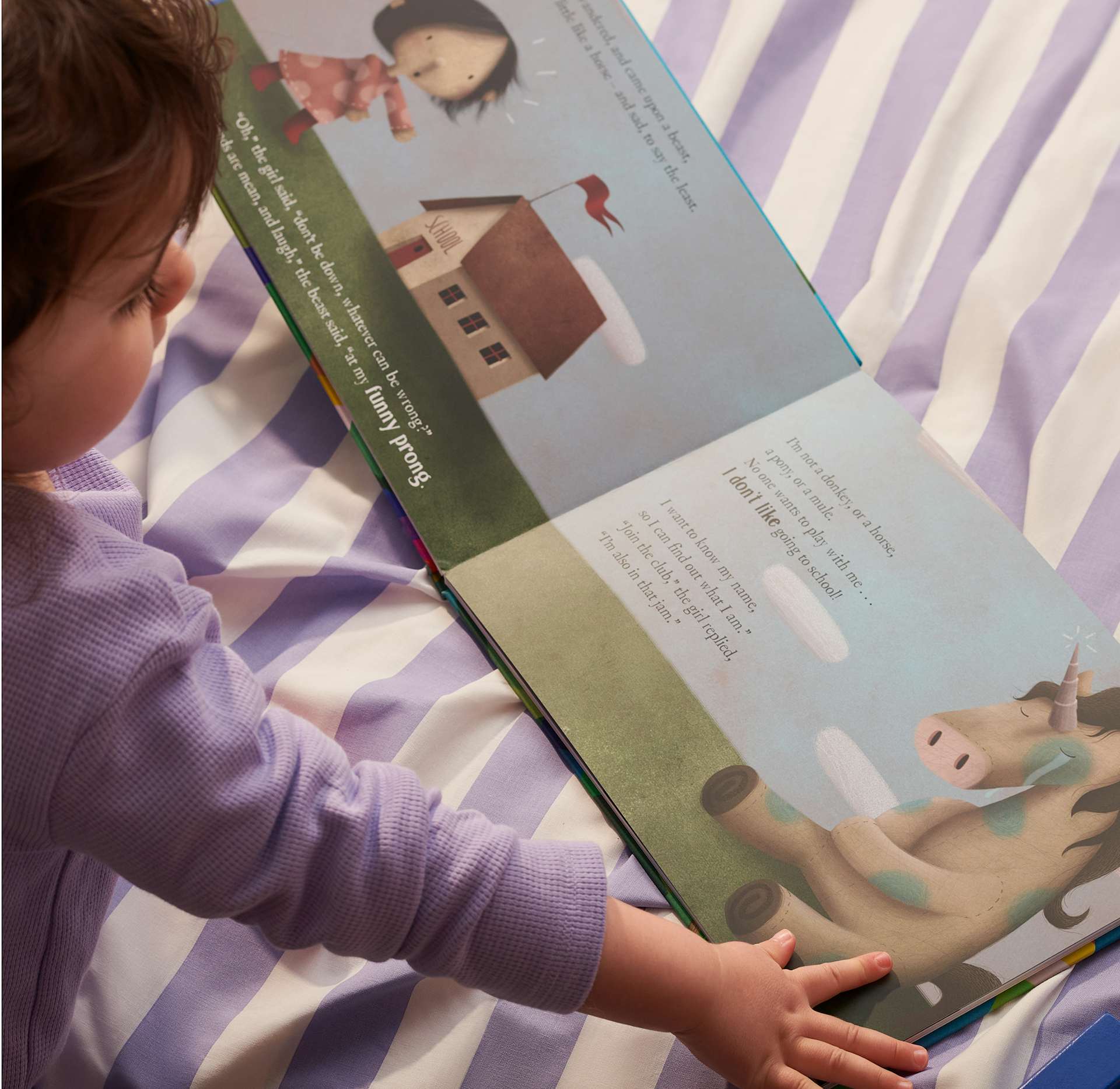child reading the book on the bed