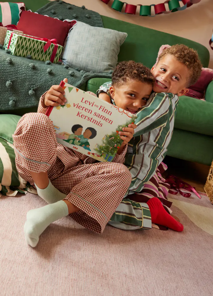 Twee kinderen lezen het gepersonaliseerde boek - Kerstmis vier je samen!