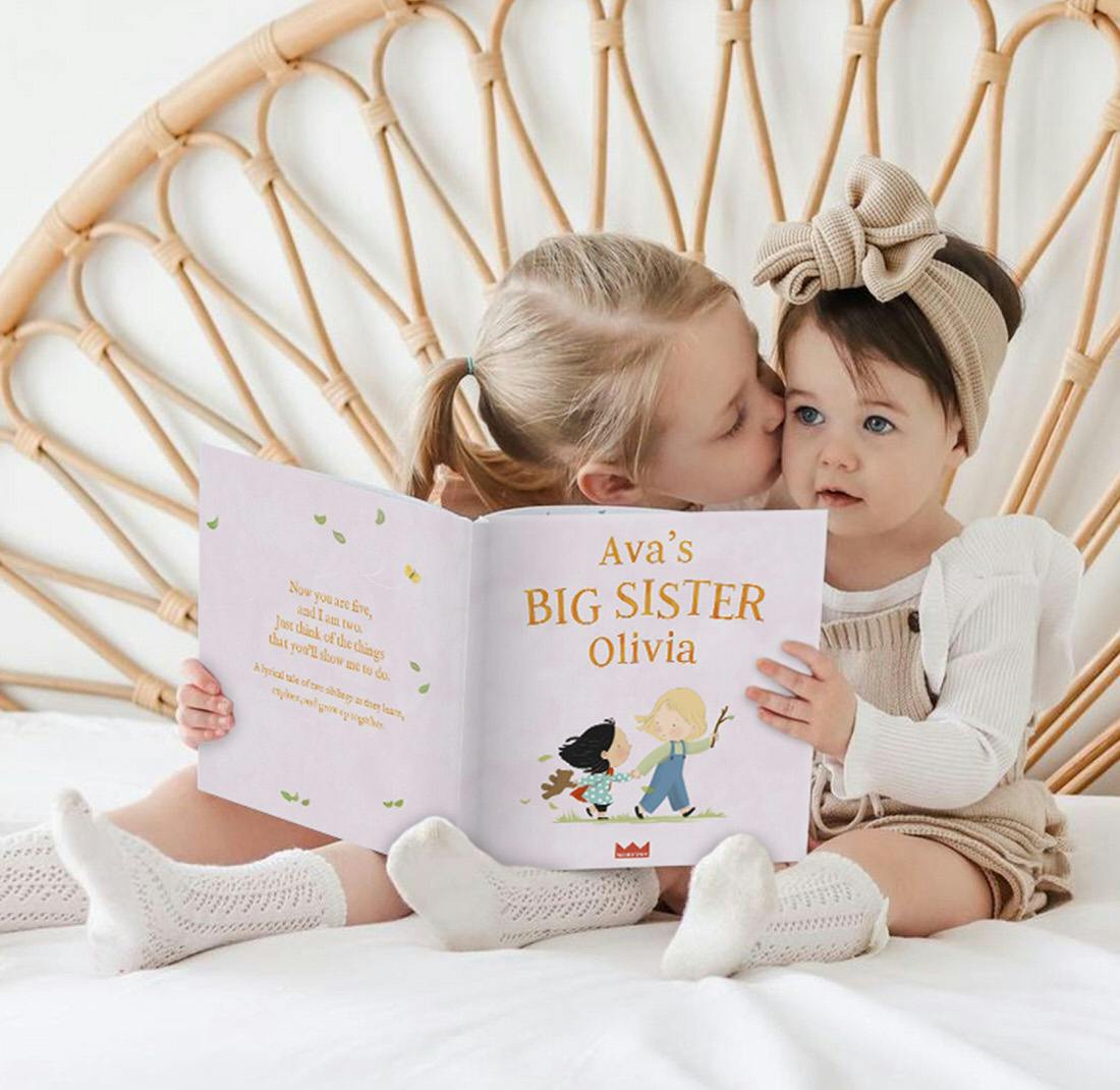 Siblings holding a personalized book
