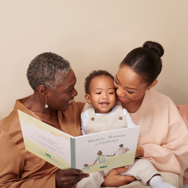 grand-mère, mère et enfant lisant un livre personnalisé