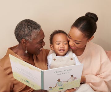 Großmutter, Mutter und Kind lesen ein personalisiertes Buch