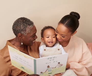 本を読む祖母、母、子供