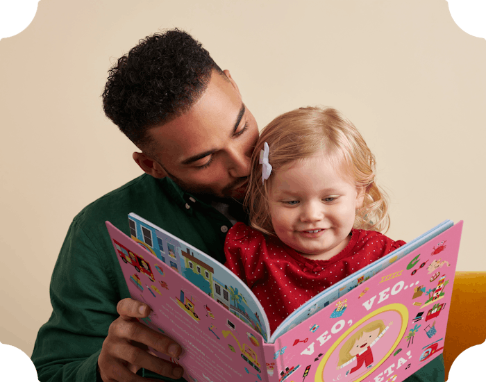 Una niña y su padre leyendo un libro personalizado