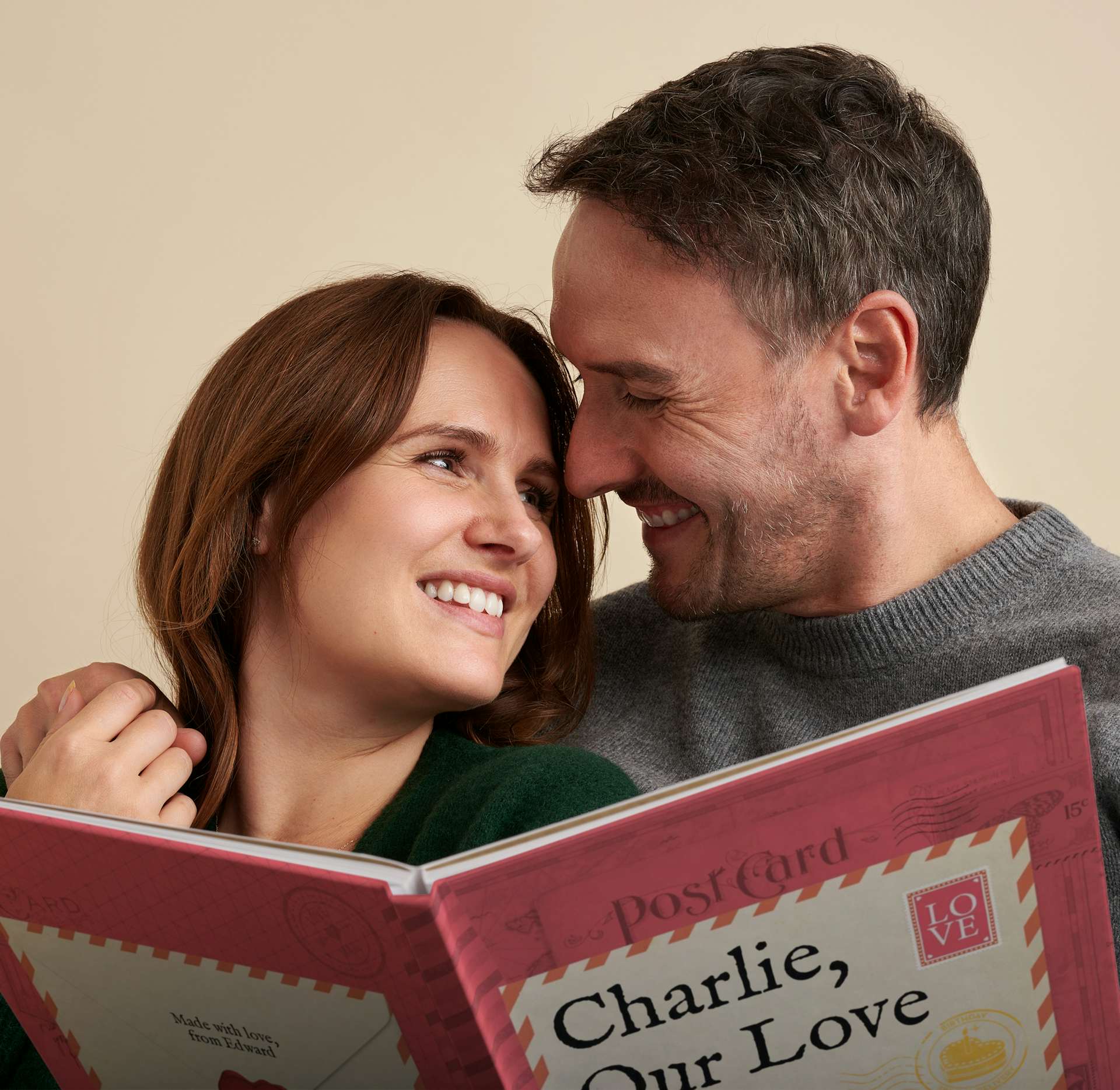 couple smiling at each other with our love story book in hand