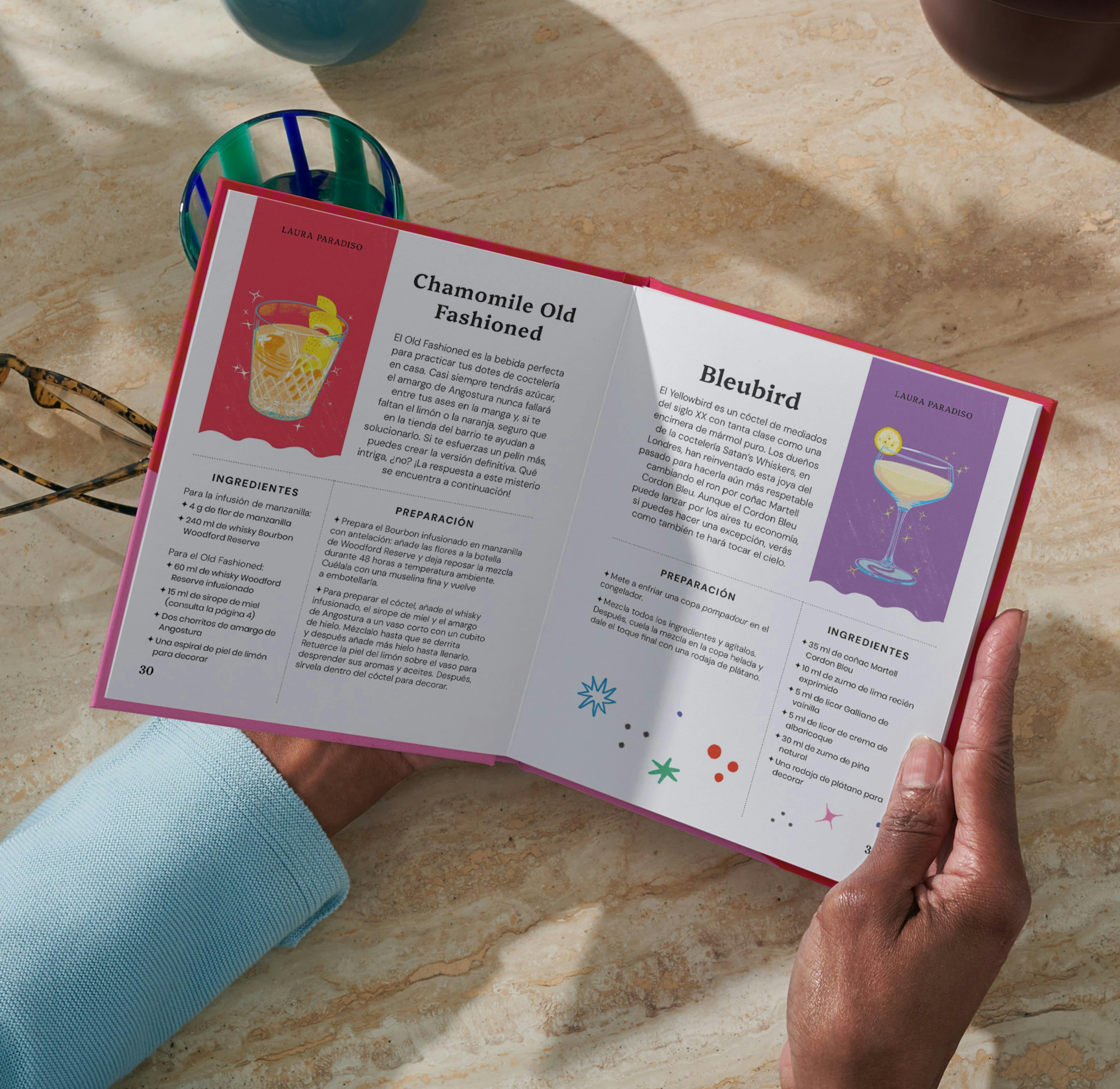 Dos manos sujetando un libro personalizado abierto