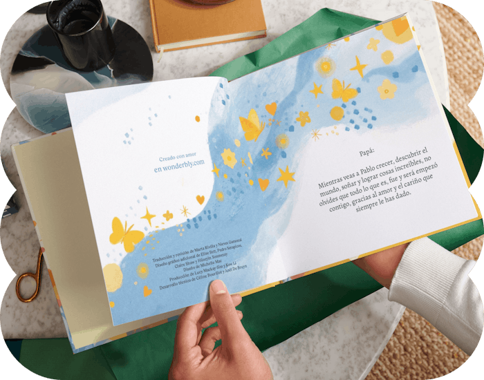 Dos manos sujetando un libro personalizado abierto