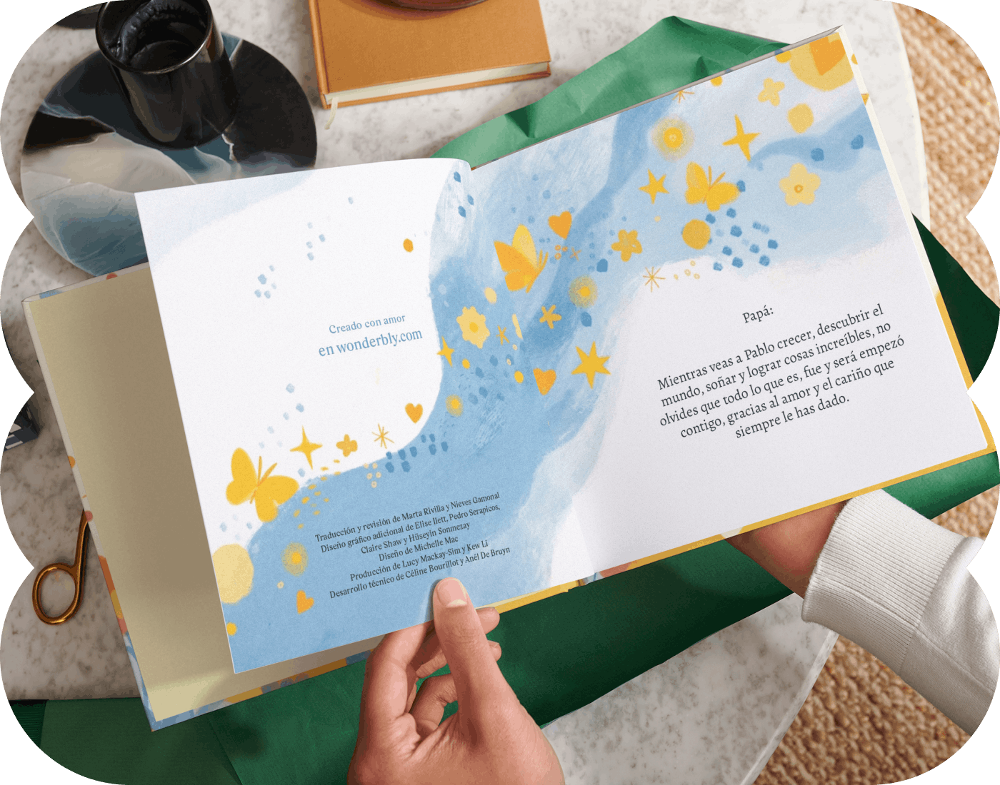 Dos manos sujetando un libro personalizado abierto