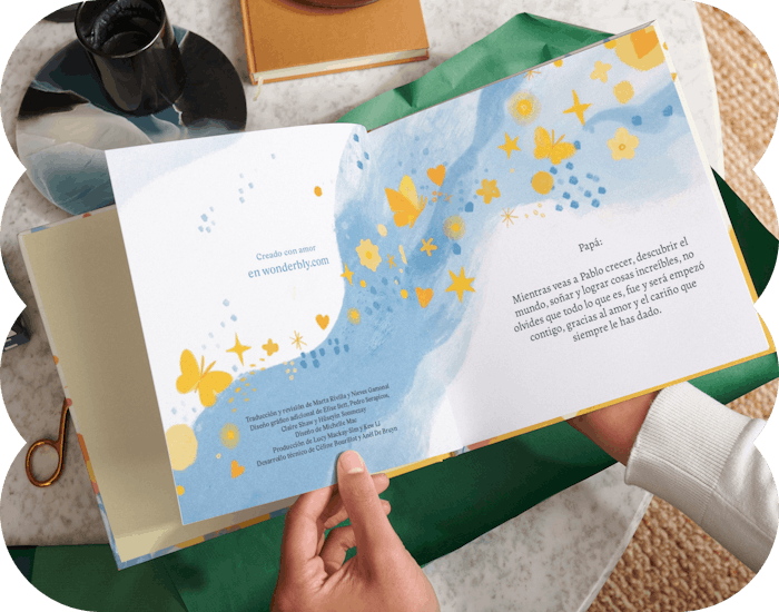 Dos manos sujetando un libro personalizado abierto