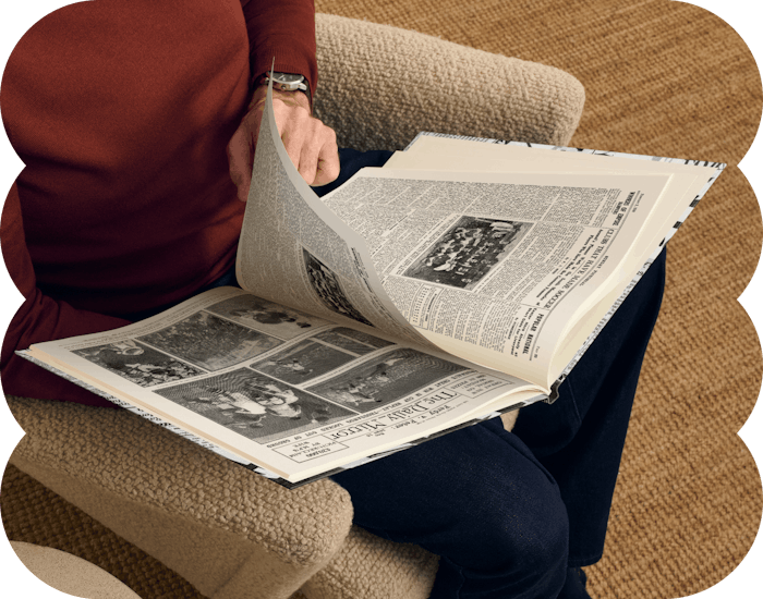 An adult reading their newspaper book