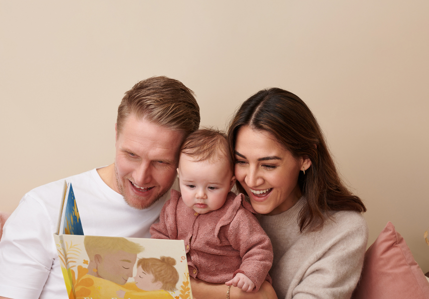 Dad, mum and baby reading personalised book