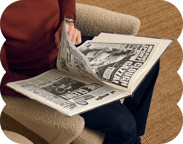 An adult reading the football headlines in the book