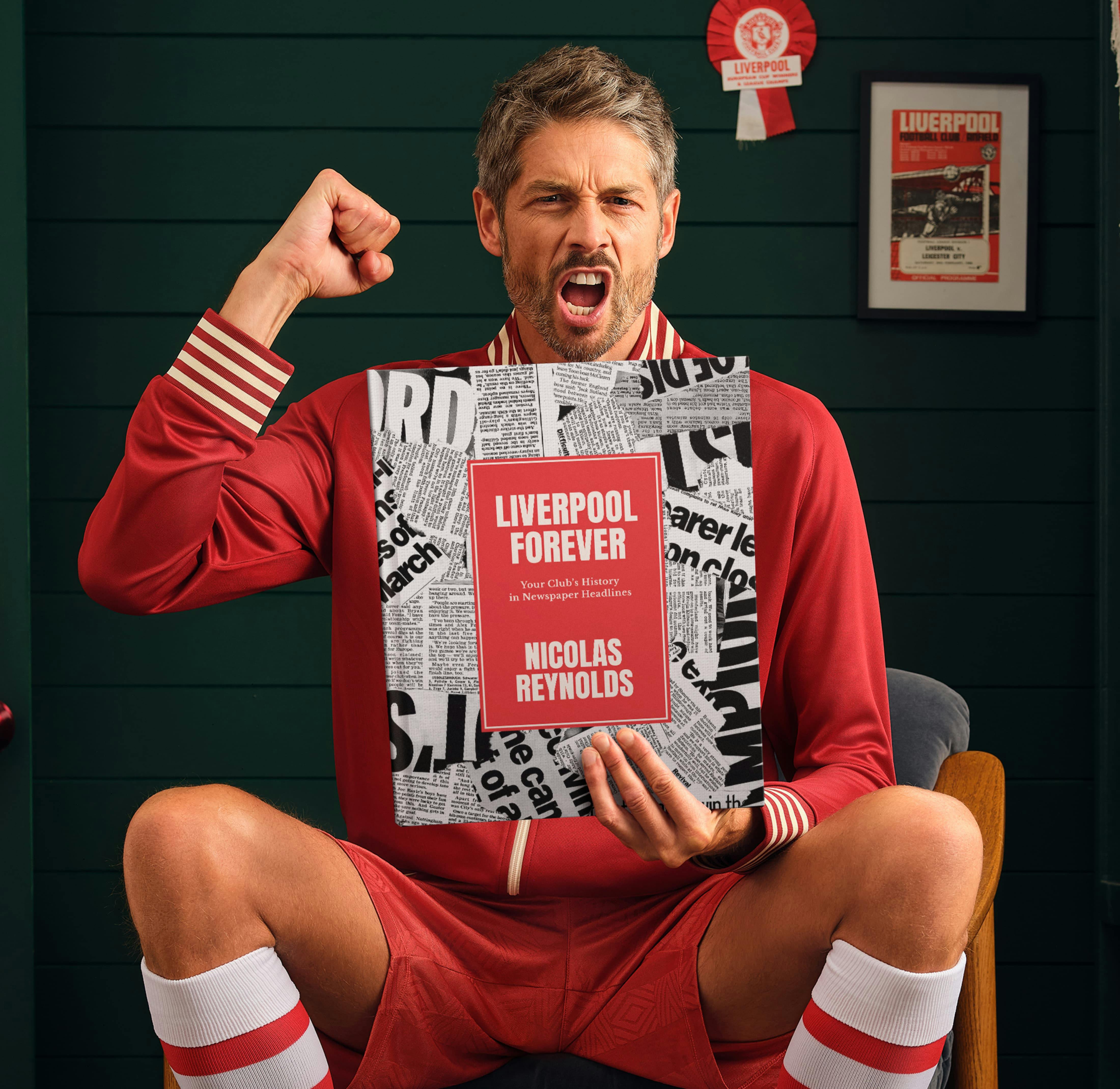 An adult football fan holding their book