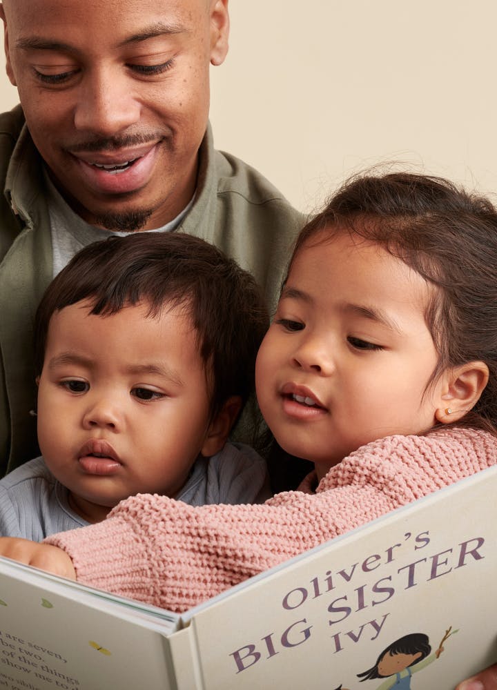 Two children and father reading the personalised book
