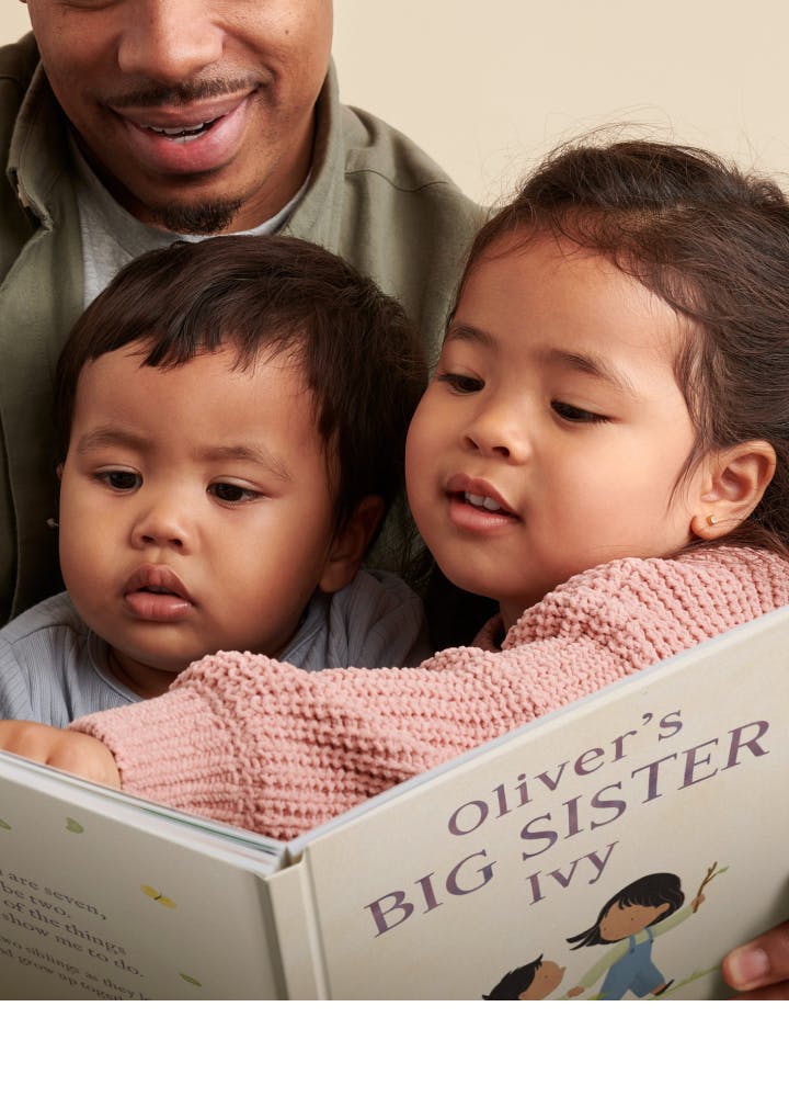Two children and father reading the personalised book